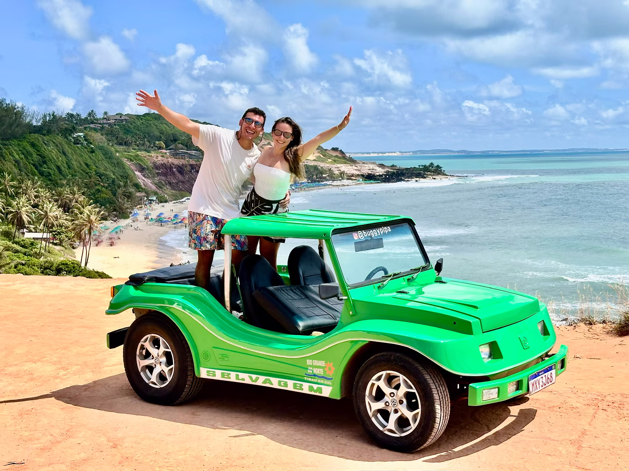 Buggy verde no mirante com a orla turquesa ao fundo