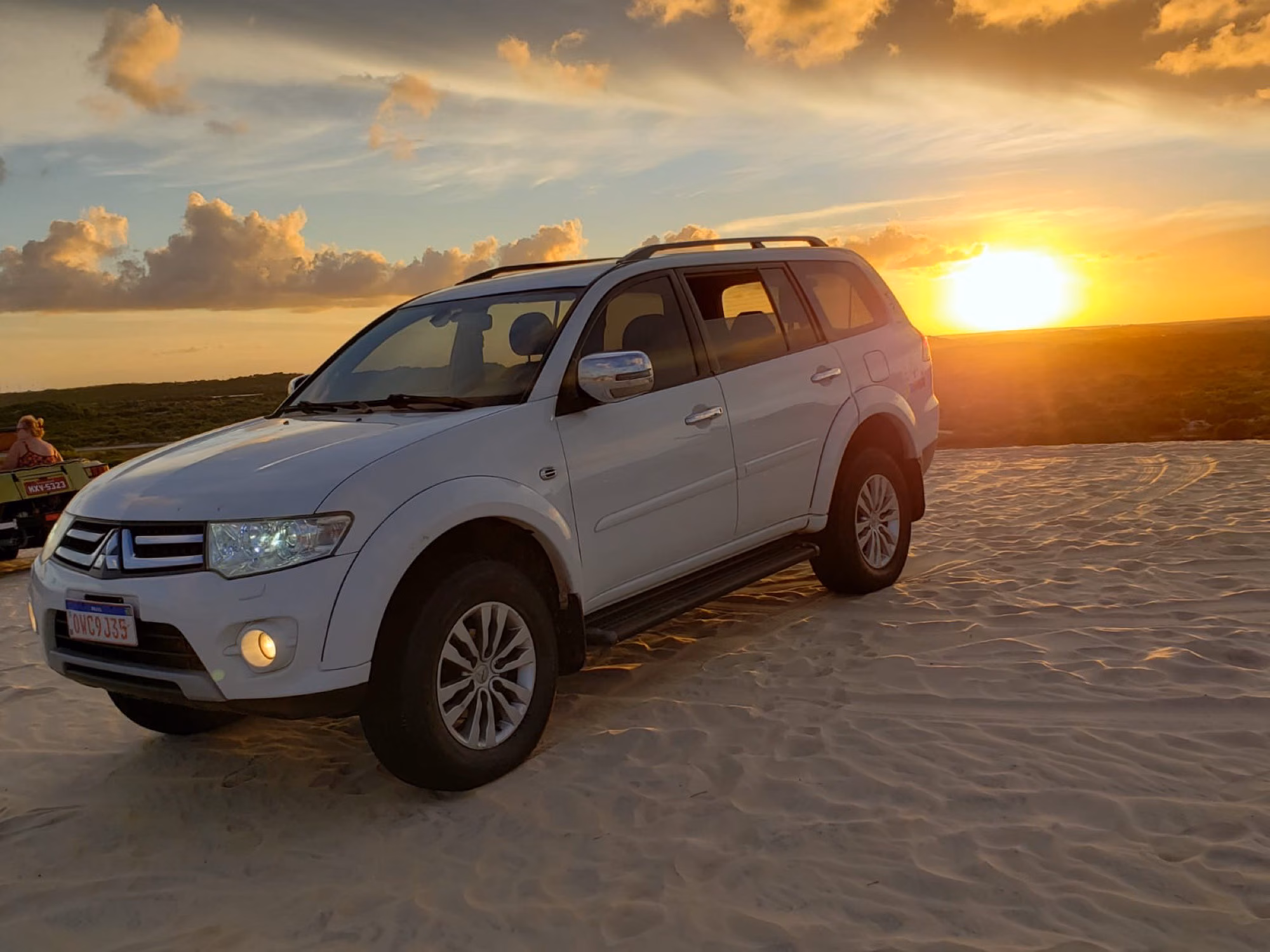 4×4 branco nas dunas no pôr do sol